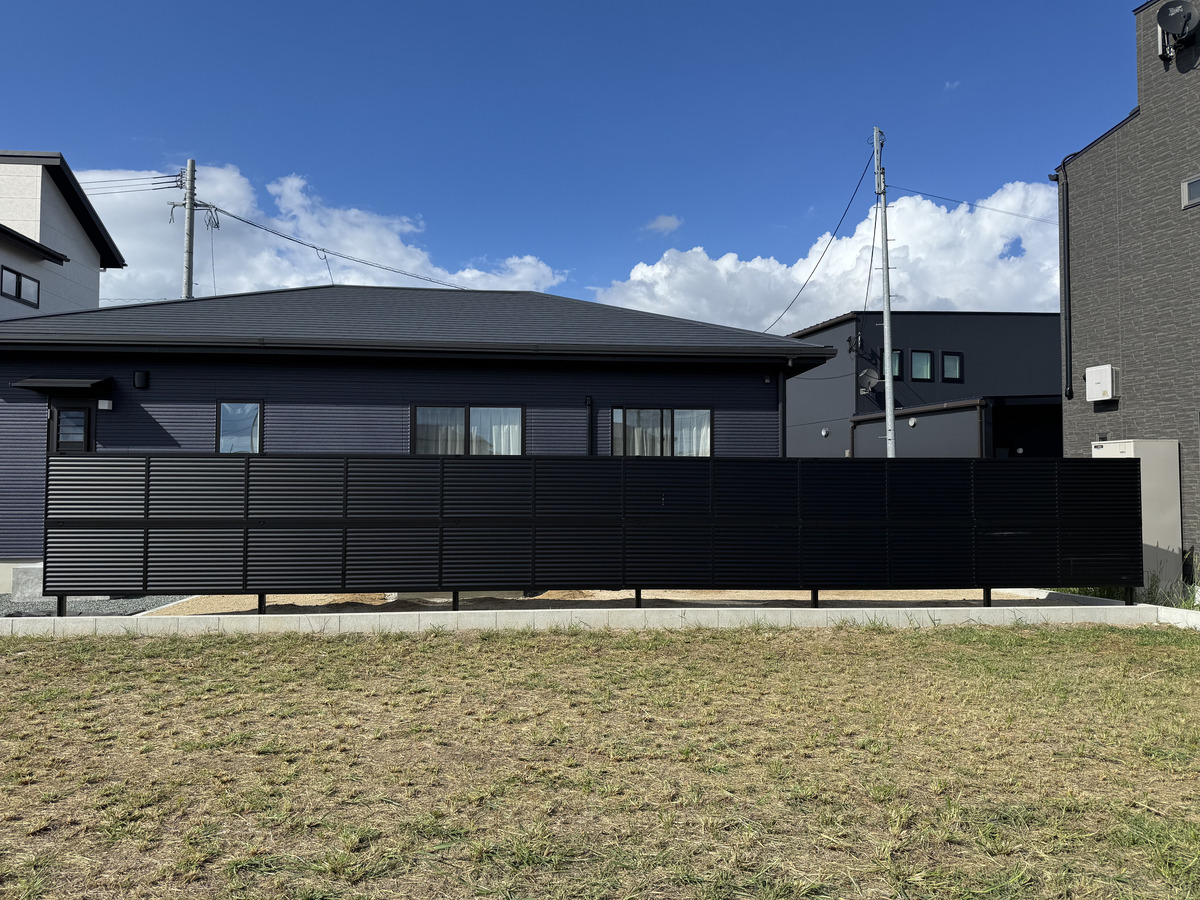 黒の横貼りフェンスでプライバシーと意匠性を両立。邸宅の風格を高めるモダンな目隠し外構
